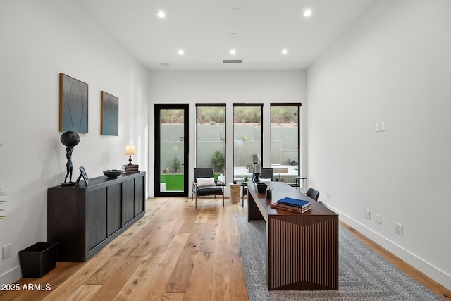 office space featuring light wood-type flooring, visible vents, baseboards, and recessed lighting