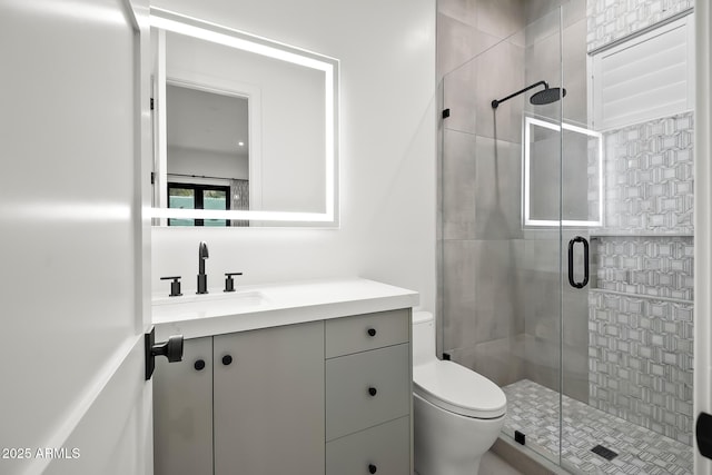 bathroom with a shower stall, vanity, and toilet