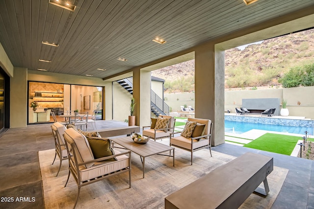 view of patio / terrace featuring stairway, a fenced backyard, a fenced in pool, and an outdoor hangout area