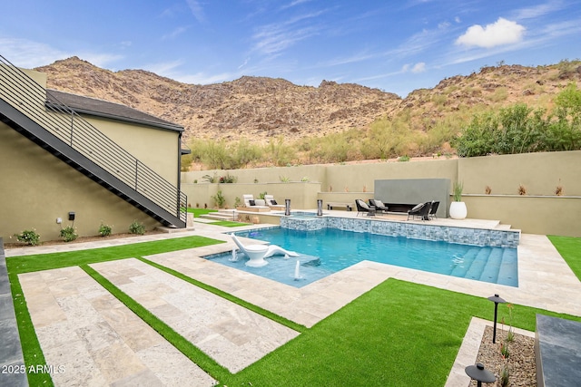 view of swimming pool featuring a patio area, a fenced in pool, a mountain view, and fence