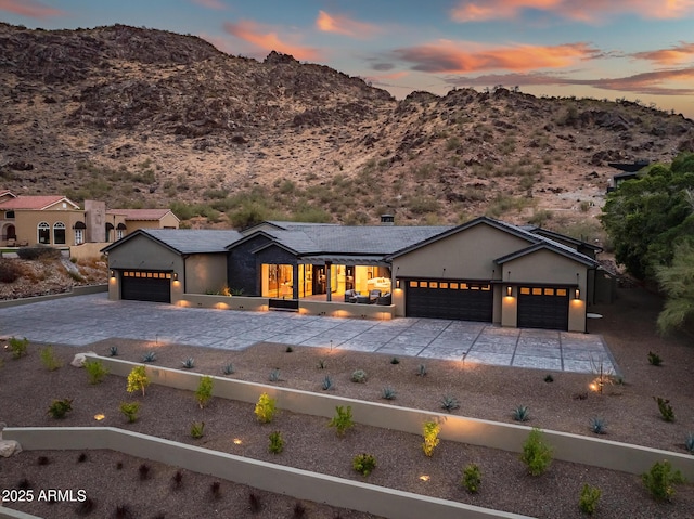 view of front of house with an attached garage, a mountain view, and driveway