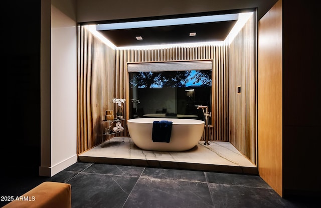 bathroom featuring baseboards and a freestanding bath