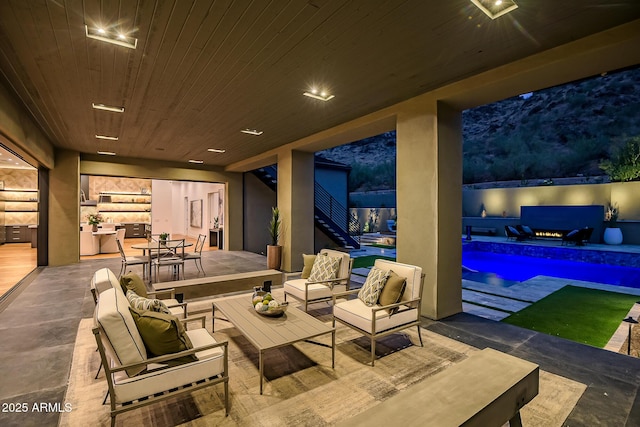 view of patio / terrace featuring stairway, outdoor dining area, a fenced in pool, and an outdoor hangout area