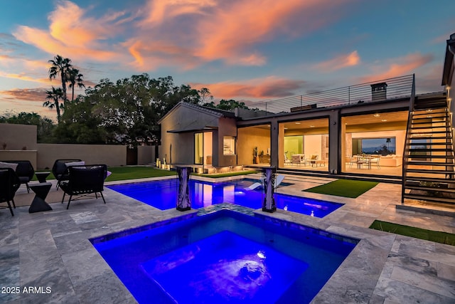 view of swimming pool with a patio, fence, stairway, a fenced in pool, and an in ground hot tub