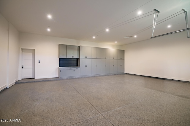 garage with recessed lighting and baseboards