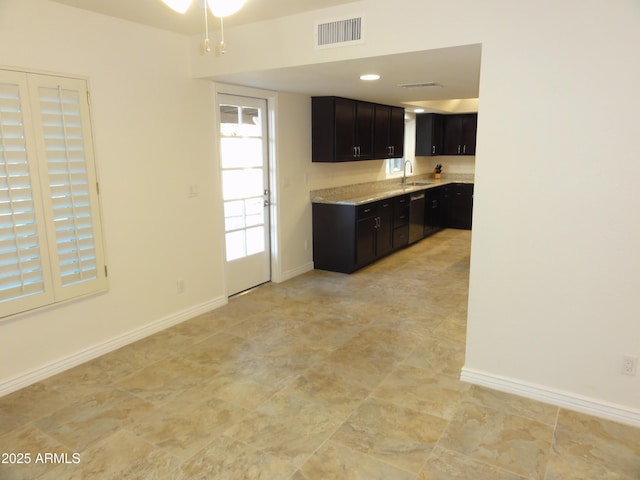 kitchen with visible vents, a sink, stainless steel dishwasher, light countertops, and baseboards