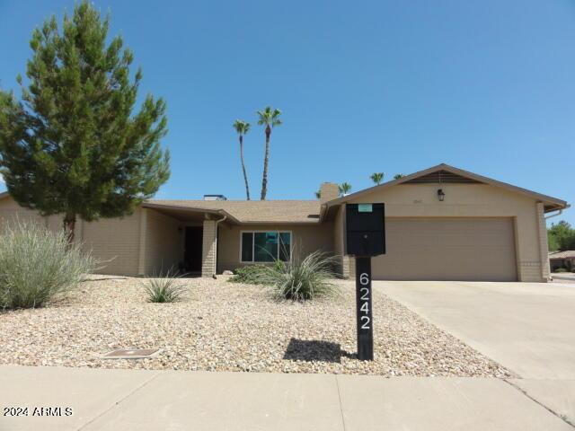 ranch-style house with an attached garage, driveway, and stucco siding