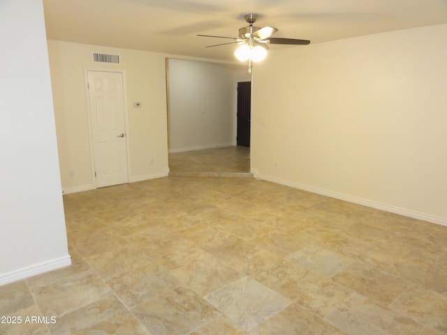 empty room with visible vents, baseboards, and ceiling fan