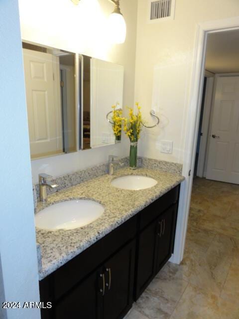 bathroom with a sink, visible vents, and double vanity