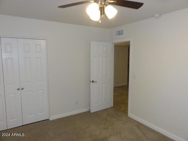 unfurnished bedroom with a closet, visible vents, baseboards, and carpet