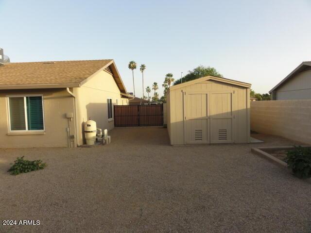 view of yard with a storage unit, an outdoor structure, and fence