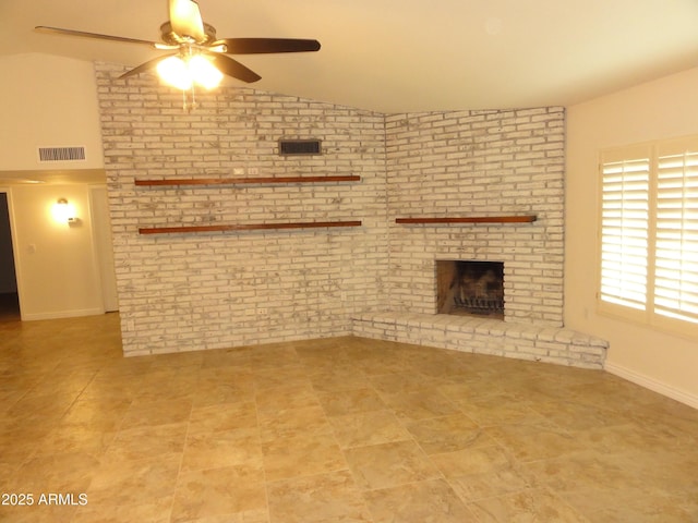 unfurnished living room with vaulted ceiling, a brick fireplace, visible vents, and brick wall