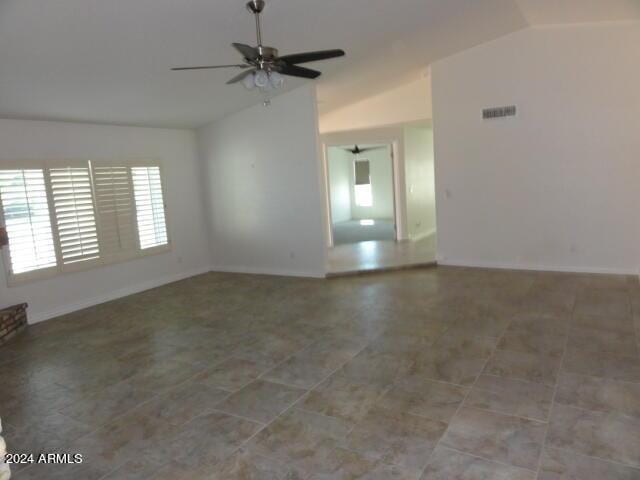 unfurnished room with visible vents, baseboards, a ceiling fan, and vaulted ceiling