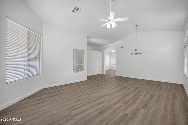 6368 W Firebird Dr, Glendale, AZ 85308 - unfurnished living room with lofted ceiling, ceiling fan, arched walkways, wood finished floors, and a chandelier
