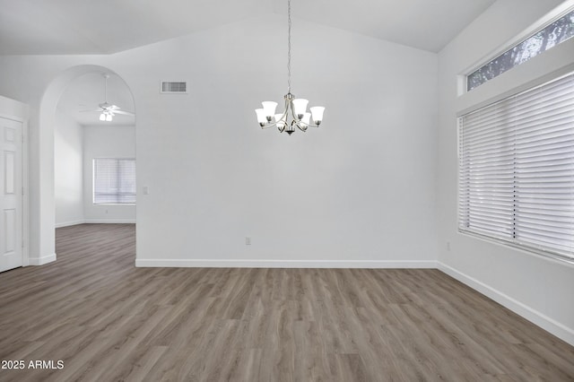 6368 W Firebird Dr, Glendale, AZ 85308 - unfurnished dining area featuring vaulted ceiling, wood finished floors, arched walkways, baseboards, and a chandelier