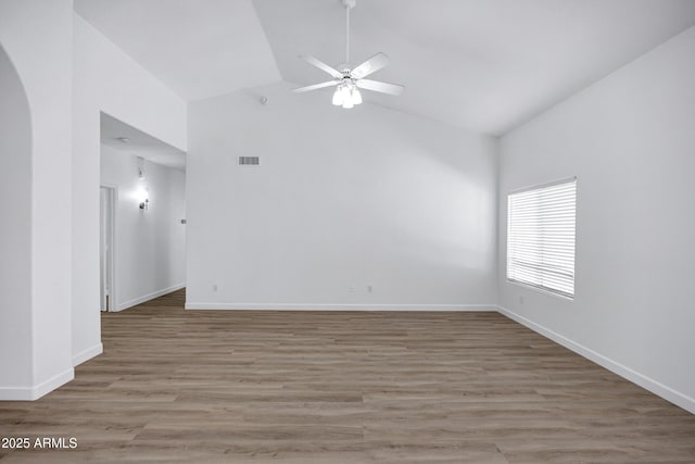 6368 W Firebird Dr, Glendale, AZ 85308 - empty room with a ceiling fan, light wood-style floors, baseboards, high vaulted ceiling, and arched walkways