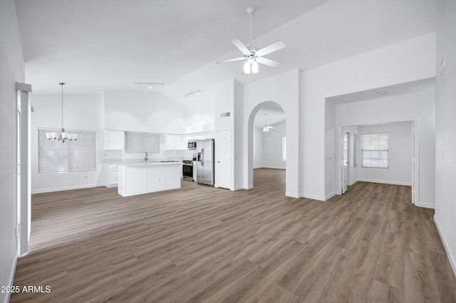 6368 W Firebird Dr, Glendale, AZ 85308 - unfurnished living room with ceiling fan, high vaulted ceiling, light wood finished floors, a sink, and a chandelier