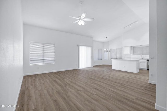 6368 W Firebird Dr, Glendale, AZ 85308 - unfurnished living room featuring a chandelier, a ceiling fan, light wood-type flooring, high vaulted ceiling, and track lighting