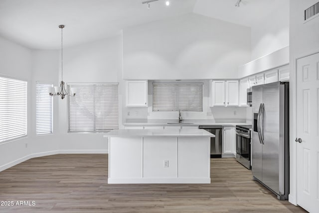 6368 W Firebird Dr, Glendale, AZ 85308 - kitchen featuring appliances with stainless steel finishes, a sink, track lighting, high vaulted ceiling, and a chandelier