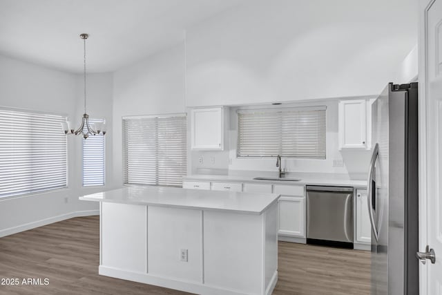 6368 W Firebird Dr, Glendale, AZ 85308 - kitchen with stainless steel appliances, a sink, a chandelier, white cabinetry, and lofted ceiling