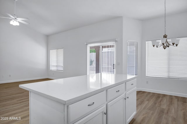 6368 W Firebird Dr, Glendale, AZ 85308 - kitchen featuring a chandelier, light wood-style floors, a ceiling fan, and white cabinetry