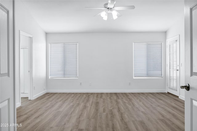 6368 W Firebird Dr, Glendale, AZ 85308 - empty room featuring wood finished floors, a ceiling fan, baseboards, and healthy amount of natural light