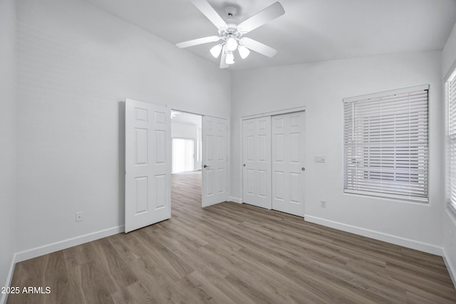 6368 W Firebird Dr, Glendale, AZ 85308 - unfurnished bedroom with baseboards, wood finished floors, a closet, ceiling fan, and high vaulted ceiling