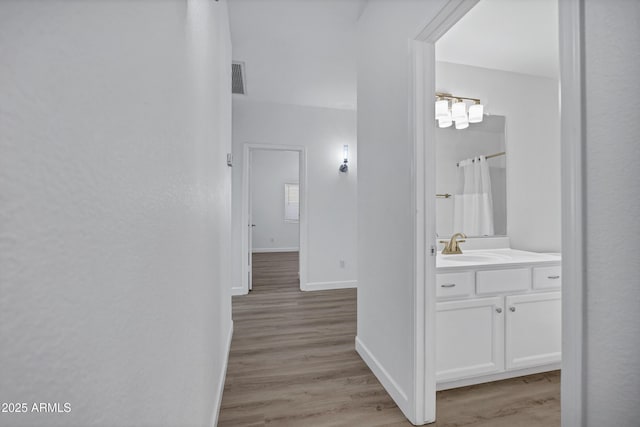 6368 W Firebird Dr, Glendale, AZ 85308 - hallway featuring light wood-style floors, baseboards, and a sink