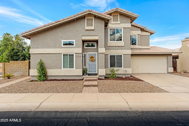 view of front of house with stucco siding, fence, driveway, and a tile roof