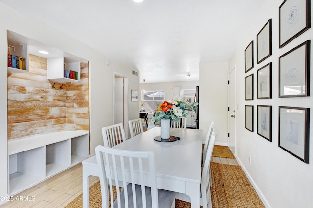 dining area featuring baseboards, visible vents, and light wood finished floors