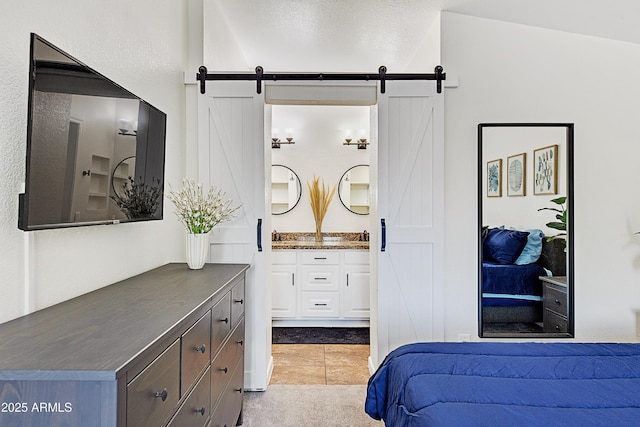 bedroom with ensuite bath and a barn door