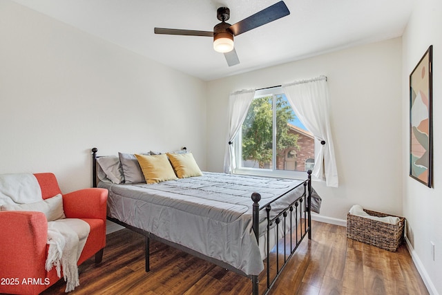 bedroom featuring a ceiling fan, baseboards, and wood finished floors