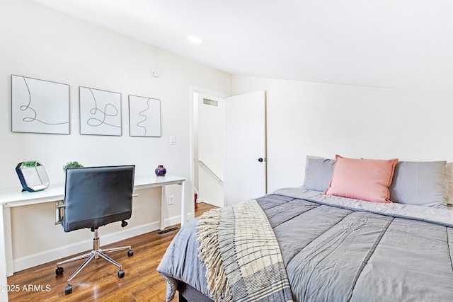 bedroom featuring baseboards, visible vents, and wood finished floors