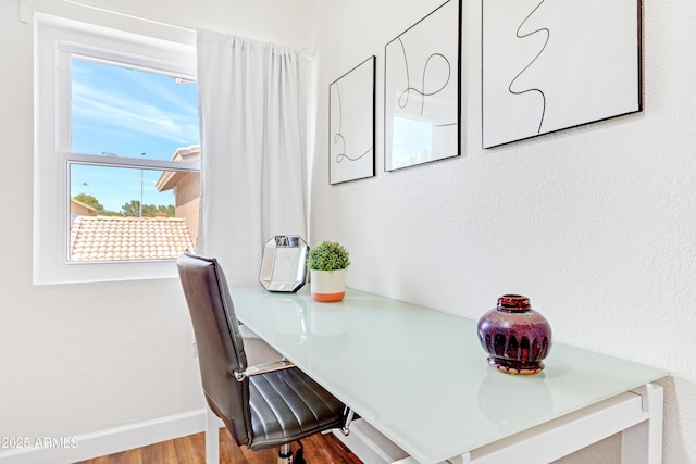 dining area with baseboards, plenty of natural light, and wood finished floors