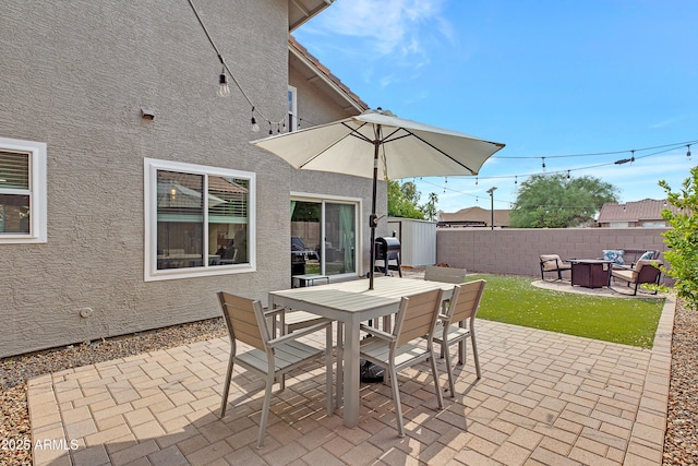 view of patio featuring outdoor dining space, a fire pit, fence private yard, and area for grilling