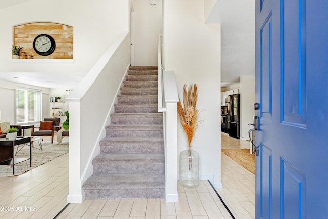 staircase with baseboards and wood finished floors
