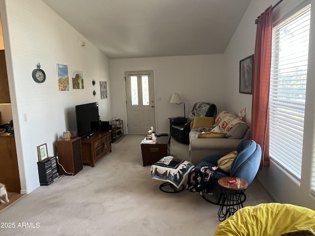 living room featuring lofted ceiling and light colored carpet