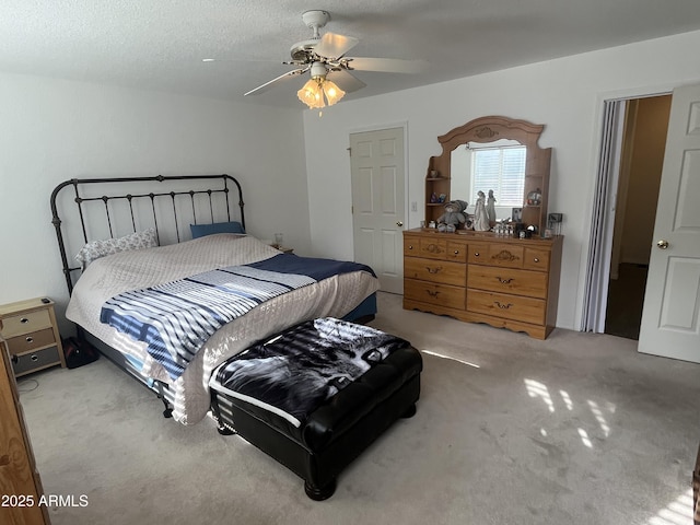 carpeted bedroom with a textured ceiling and ceiling fan