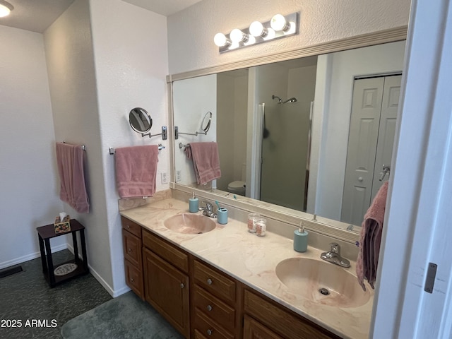 bathroom with vanity, toilet, and a shower