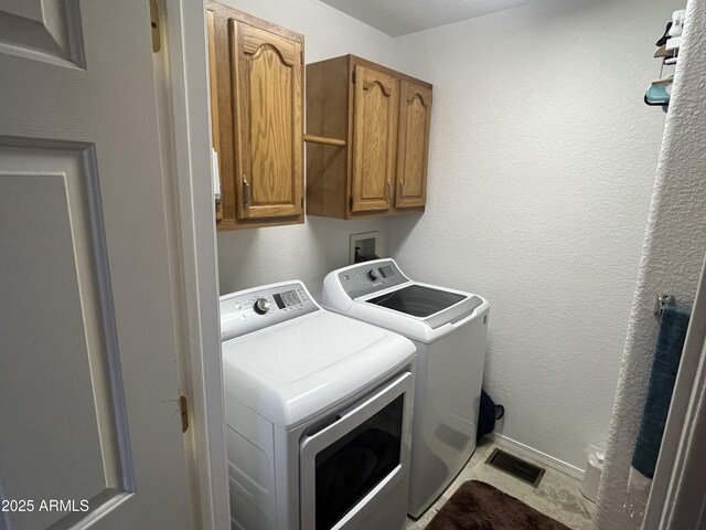 laundry area featuring cabinets and washing machine and clothes dryer