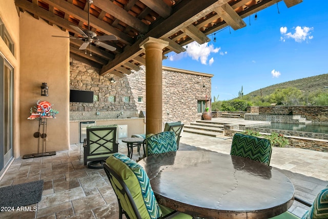 view of patio with an outdoor kitchen and ceiling fan