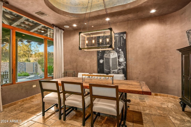 dining area with a tray ceiling and a notable chandelier