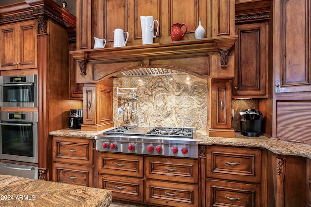 kitchen featuring backsplash, light stone counters, and stainless steel appliances