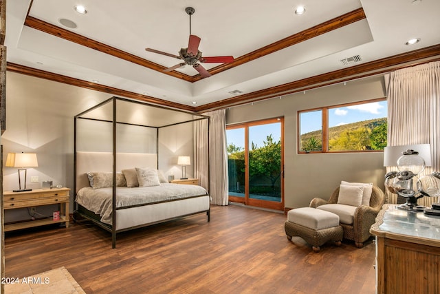 bedroom with dark hardwood / wood-style flooring, access to outside, a raised ceiling, and ceiling fan