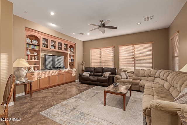 living room with ceiling fan and built in features