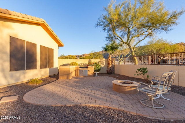 view of patio with an outdoor fire pit and exterior kitchen