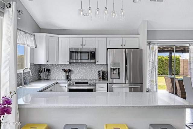 20822 N 34th Dr, Phoenix, AZ 85027 - kitchen featuring appliances with stainless steel finishes, a sink, light stone counters, backsplash, and a peninsula