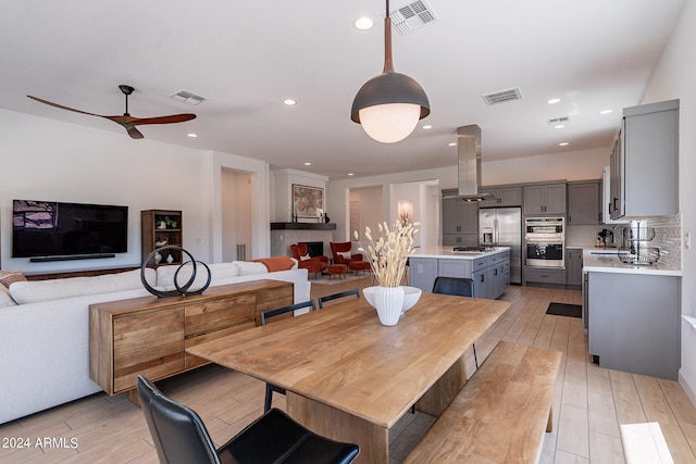 dining area with sink, light hardwood / wood-style flooring, and ceiling fan