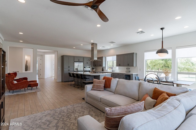 living room featuring wine cooler, sink, and light hardwood / wood-style flooring