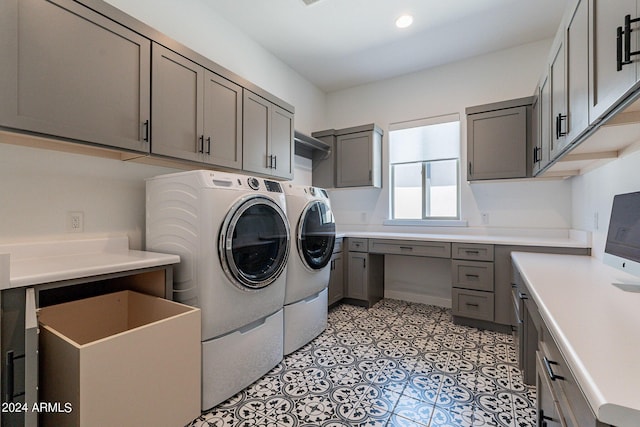 clothes washing area with cabinets and separate washer and dryer